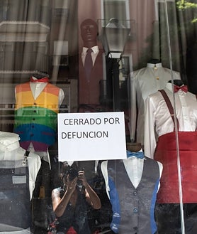 Imagen secundaria 2 - Un indigente duerme entre colchones en Tirso de Molina; carteles de los vecinos denunciando el ruido y la basura; y letrero en la tienda que regenta el marido de Concha, también de uniformes