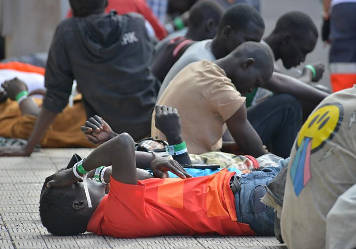 Migrantes rescatados de un cayuco descansan en el muelle de la Restinga, El Hierro