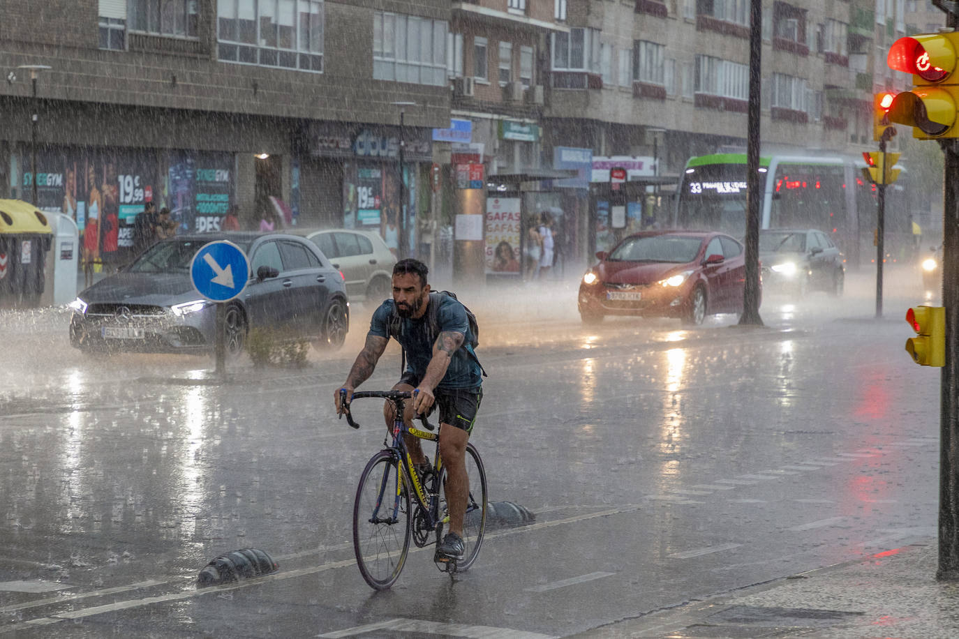 Ciclista bajo la lluvia por el centro de Zaragoza