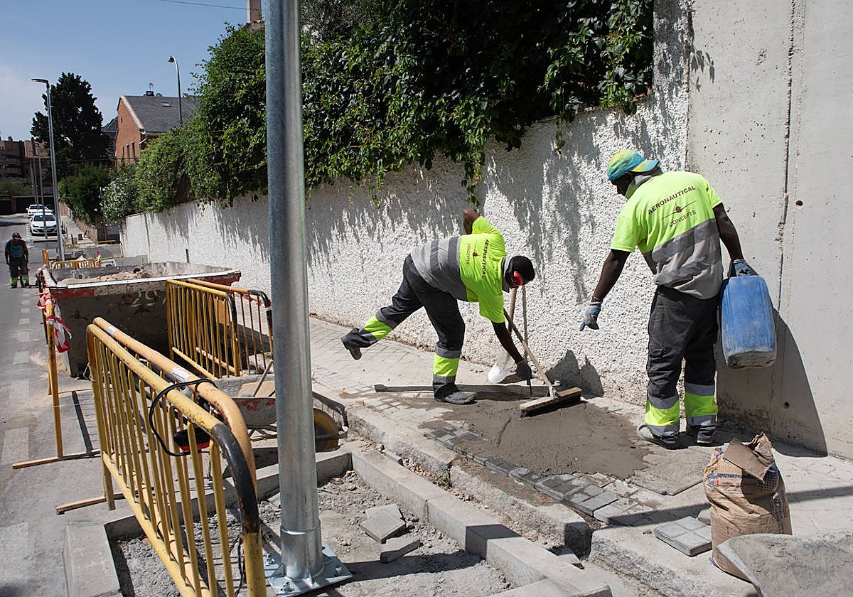 Trabajadores tapan el hueco que ha dejado una farola en la acera