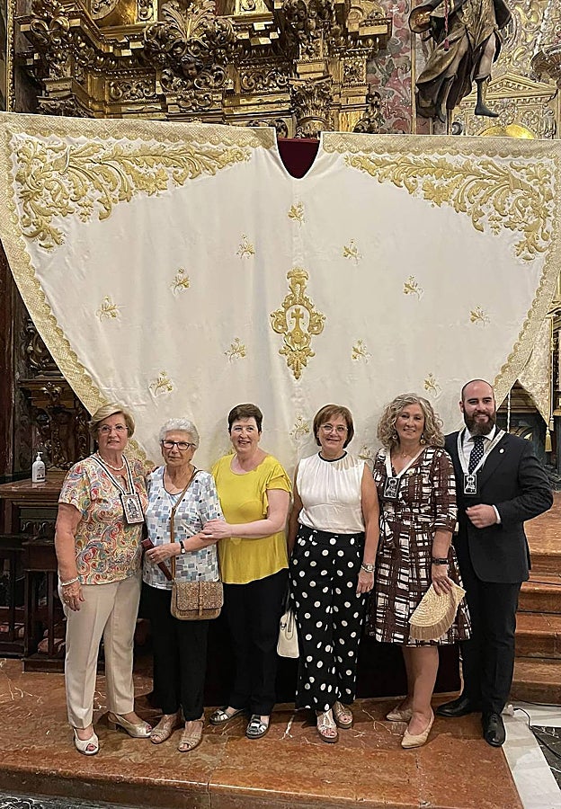 Integrantes del taller de la archicofradía, junto al diseñador Pedro José Sánchez Reyes, ante la nueva capa de la Virgen del Carmen de San Cayetano tras su bendición