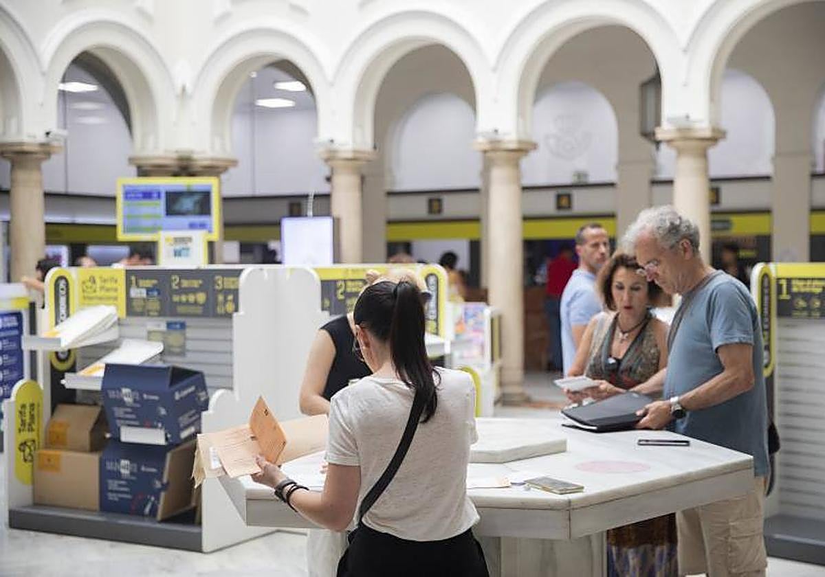 Personas en una oficina de Correos
