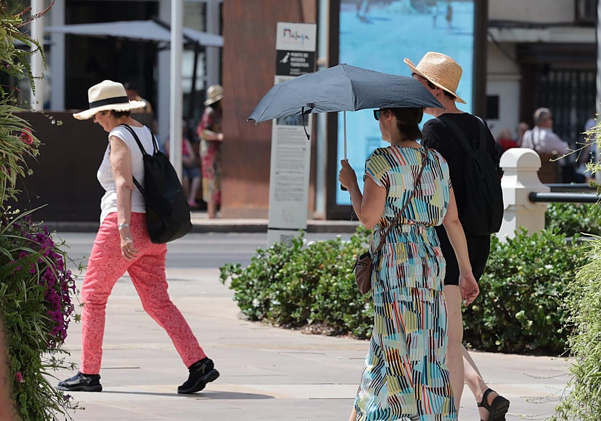 Ua turista se protege del sol en el centro de Málaga