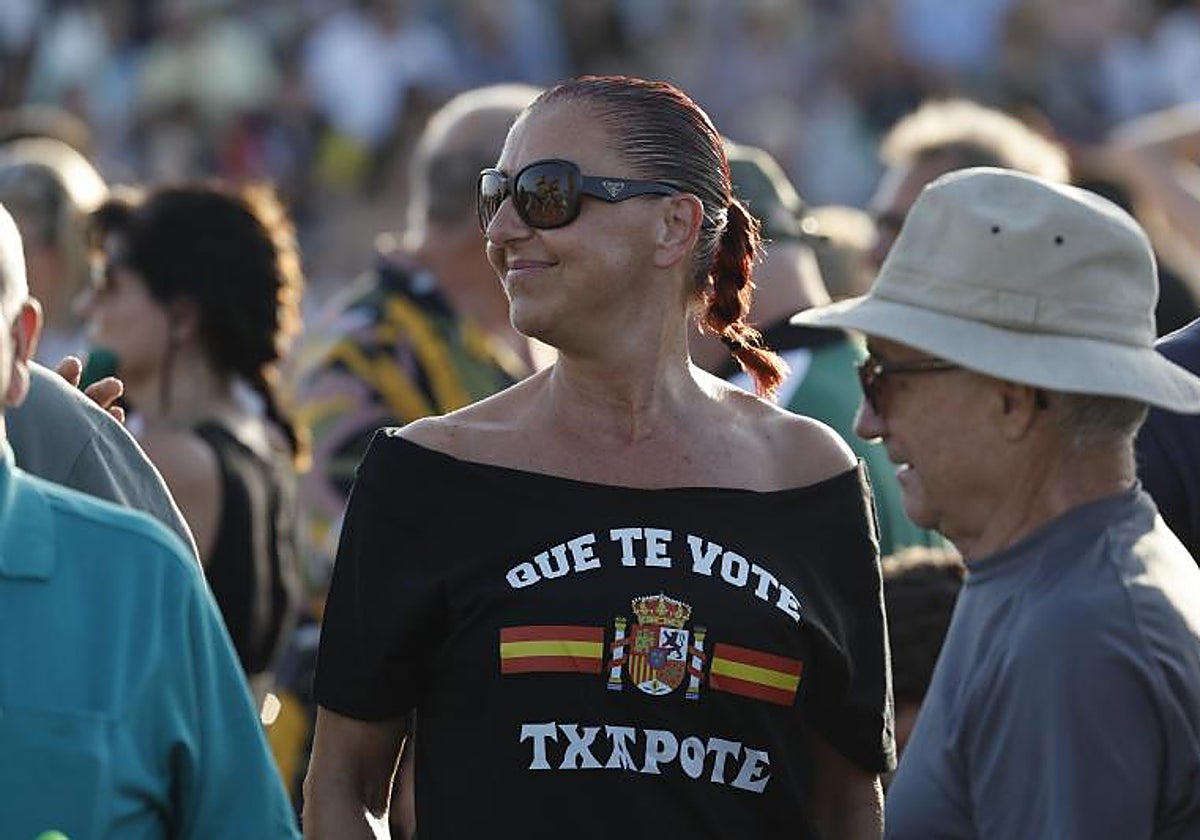 Una mujer luce una camiseta con el lema «Que te vote Txapote» durante el acto electoral del candidato de Vox a la Presidencia del Gobierno, Santiago Abascal, en Valencia, este jueves