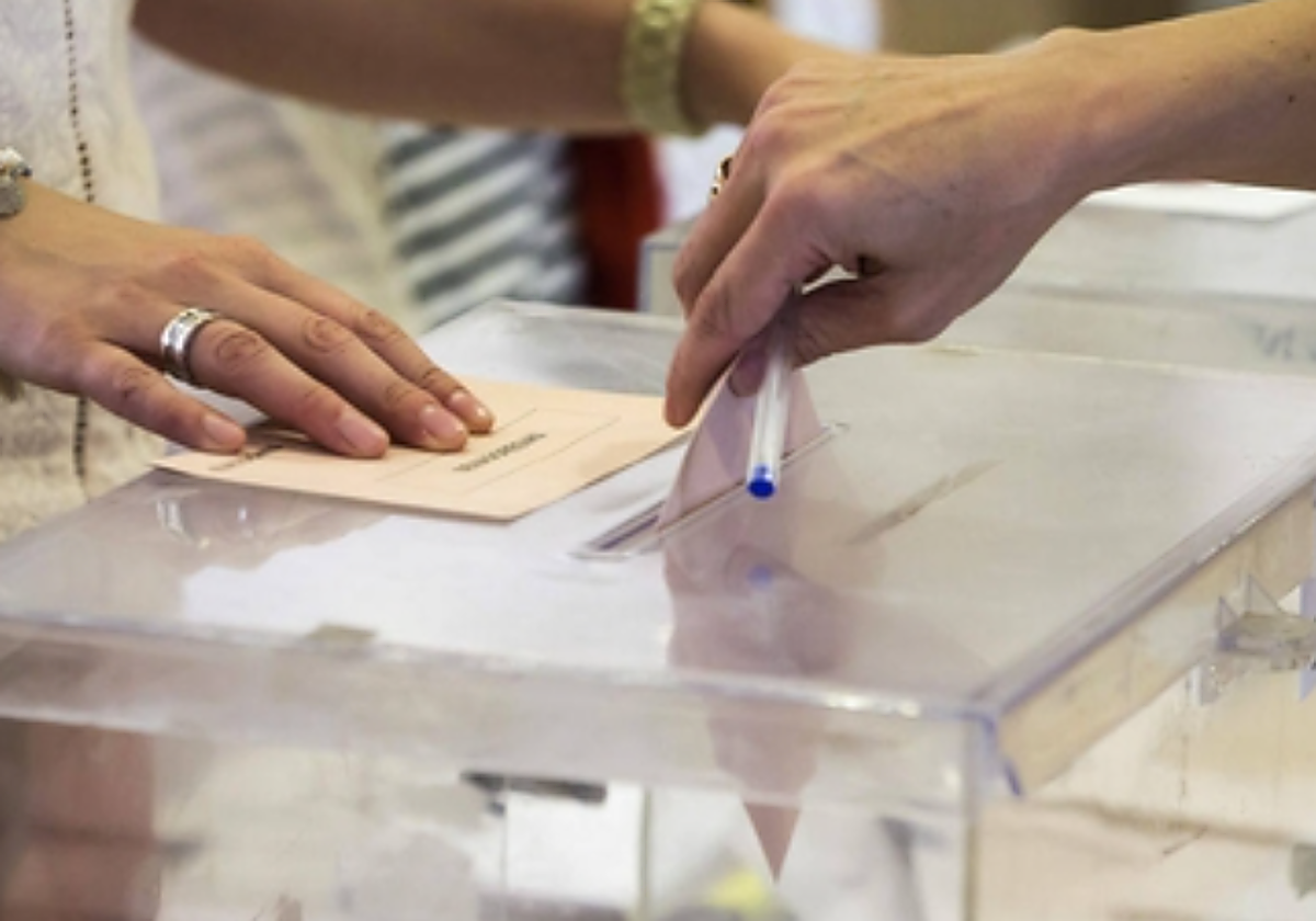 Un votante deposita su sobre en una urna electoral