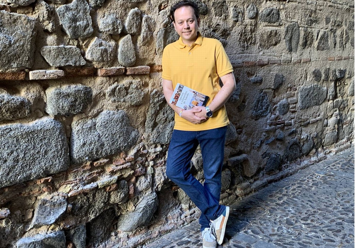 El periodista y escritor, Javier Guayerbas, posa con su nuevo libro, 'Iglesias y conventos de Toledo', en la zona conventual de la capital regional