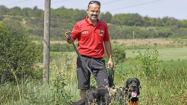 Xot, junto a su guía y dueño, con el arnés de trabajo