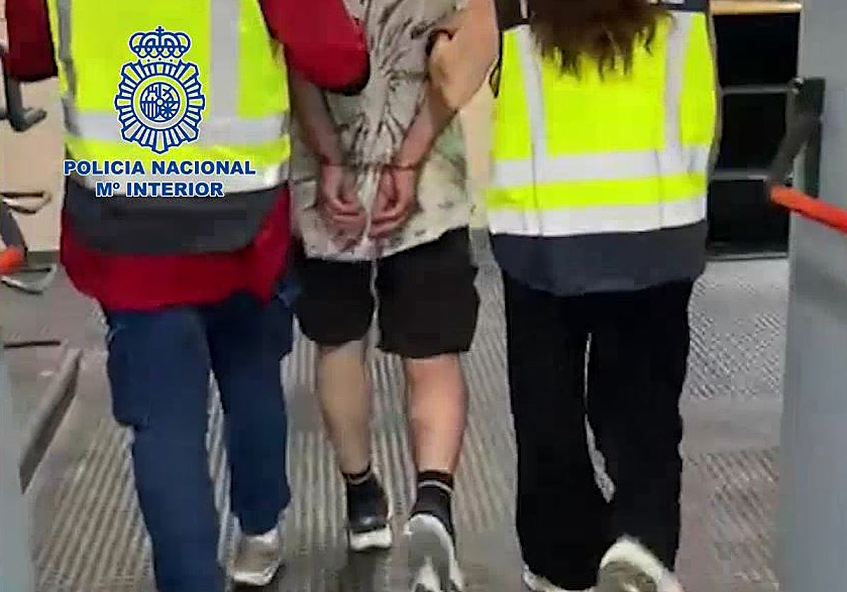 Dos agentes conducen al arrestado por dependencias policiales