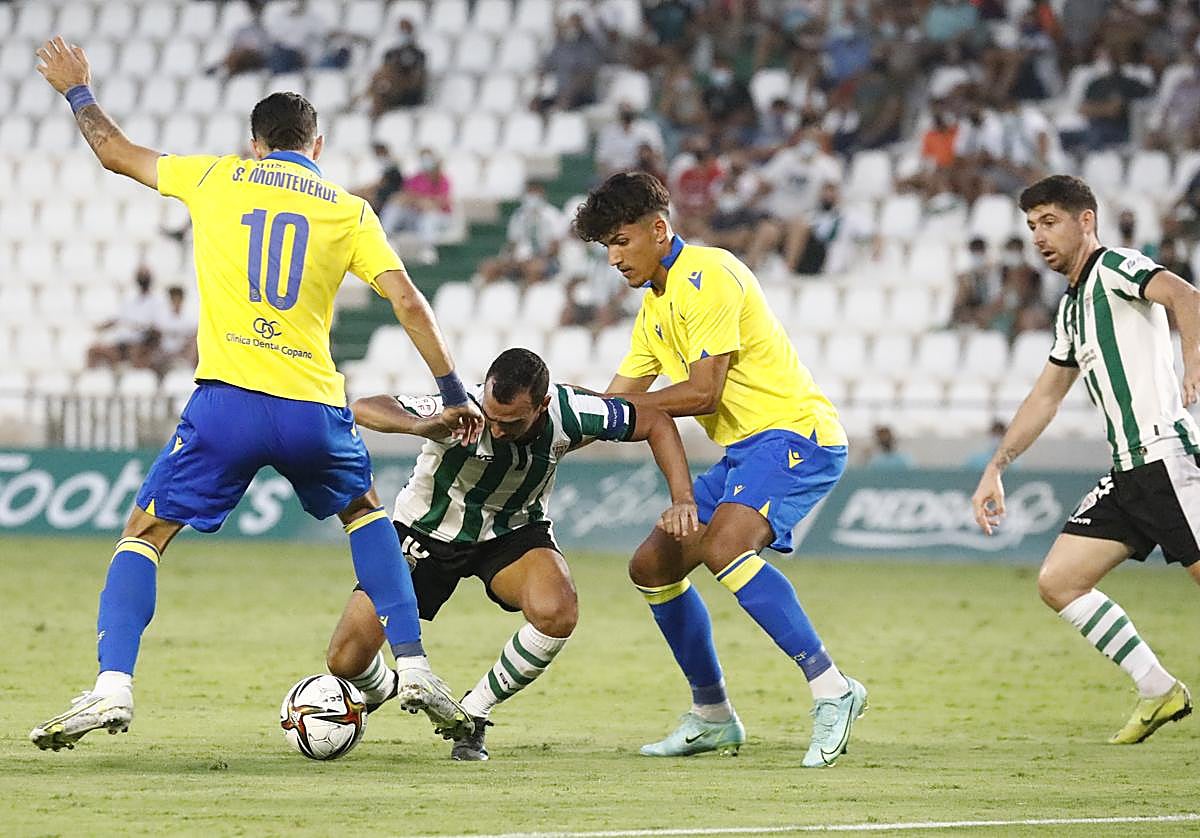 Los jugadores del Córdoba CF frente a dos rivales cadistas