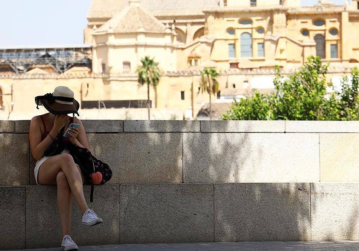 Una mujer se resguarda del sol a la sombra en Córdoba
