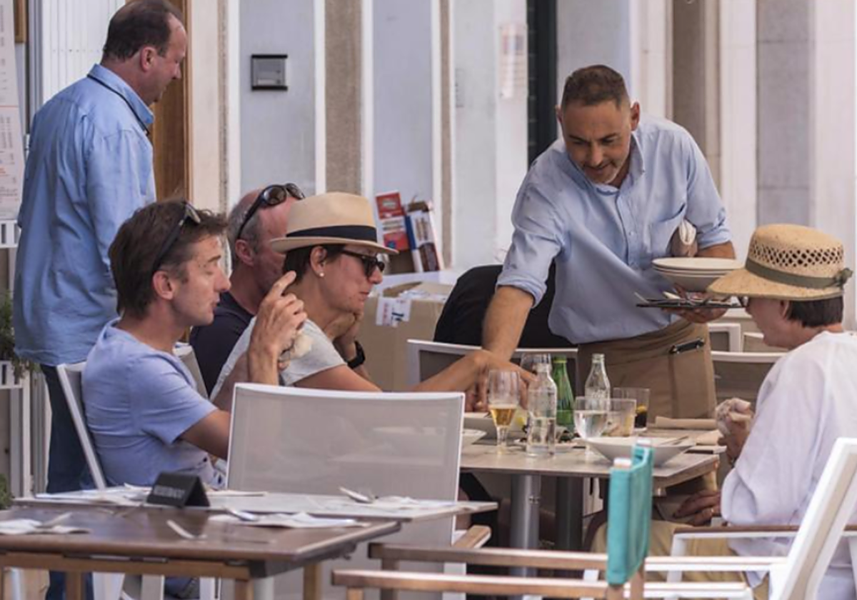 Un camarero atiende una mesa en foto de archivo