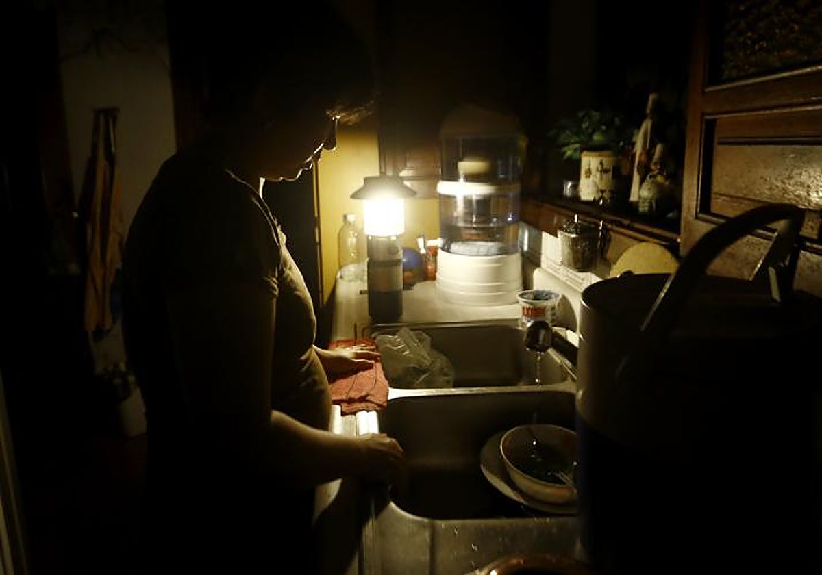Imagen de archivo de una mujer en su casa durante un apagón