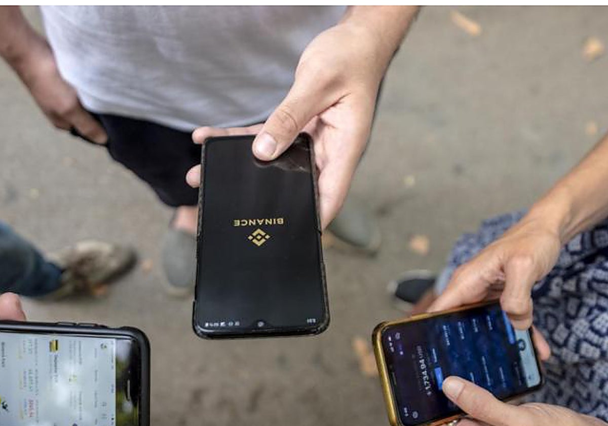Imagen de archivo de tres jóvenes con sus respectivos teléfonos móviles