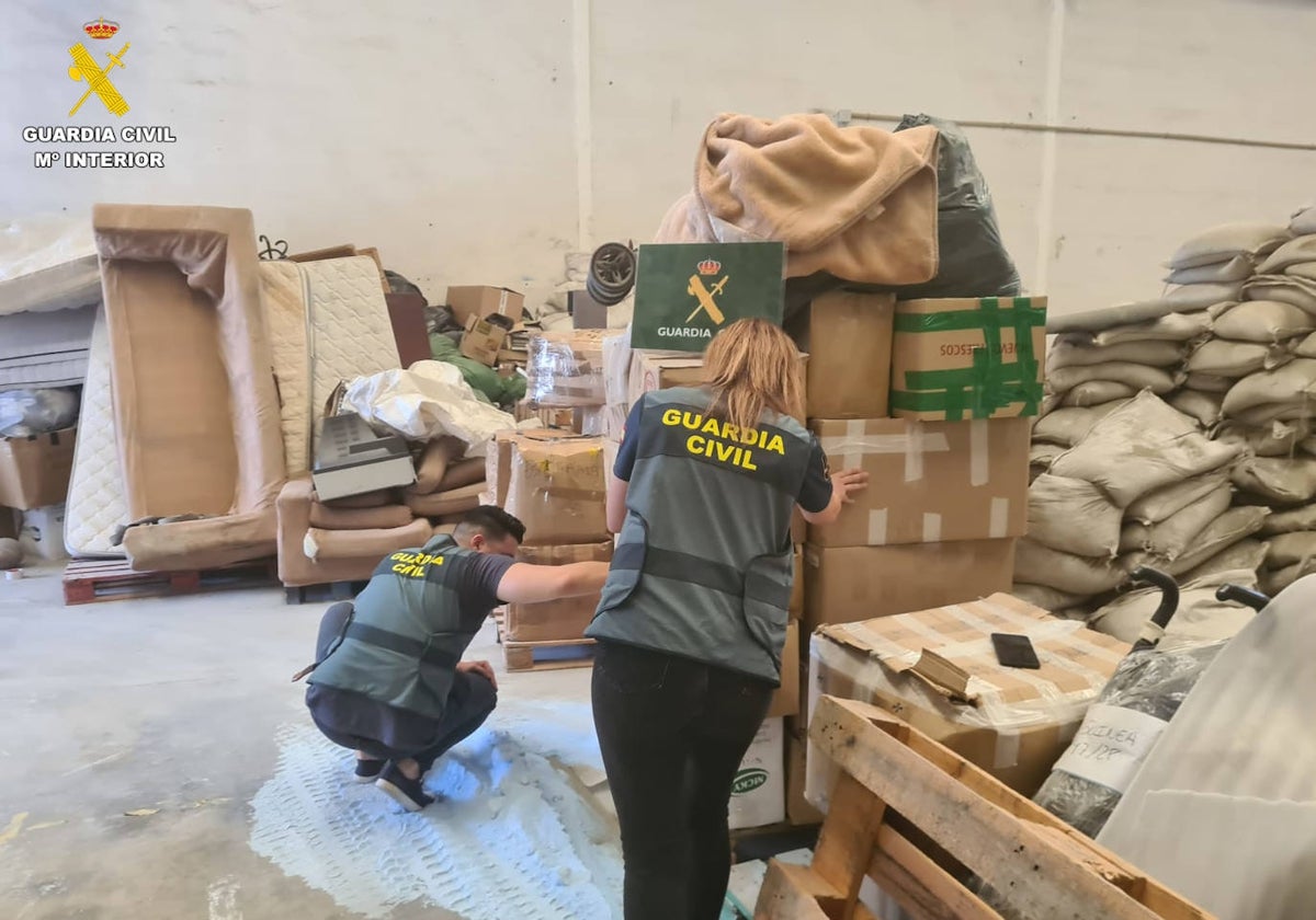 Dos guardias civiles en la nave industrial donde el presunto estafador guardaba los pedidos de sus clientes