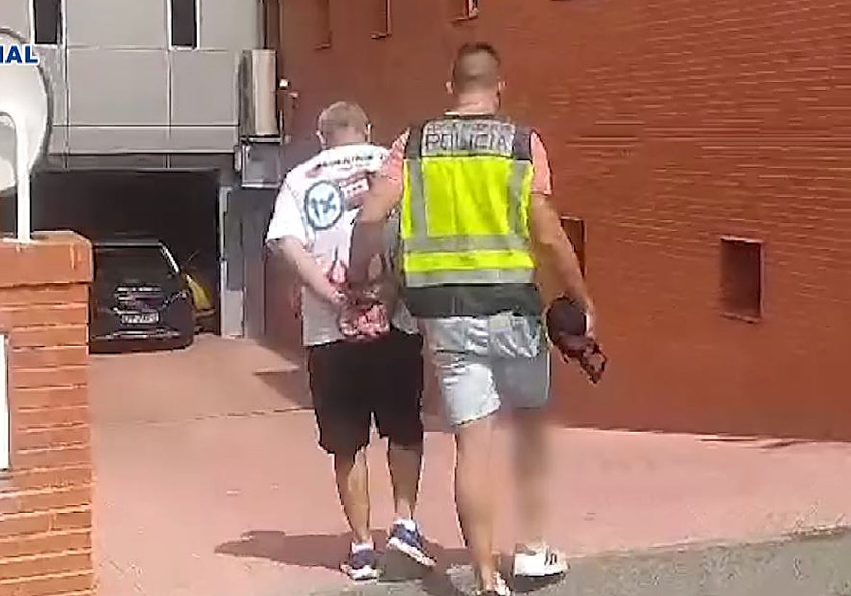 Un agente conduce al hombre arrestado en dependencias policiales