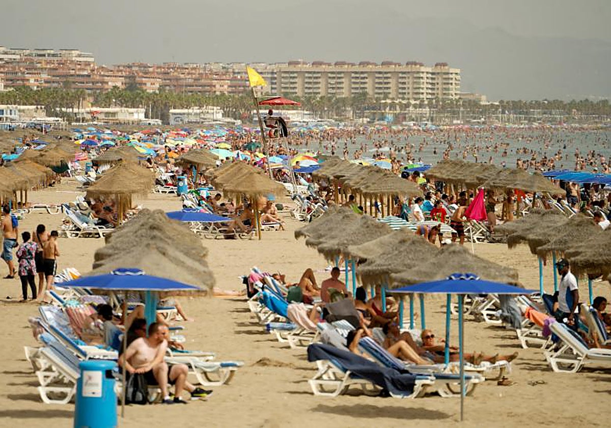 Turistas y bañistas en la playa de la Malvarrosa en Valencia.
