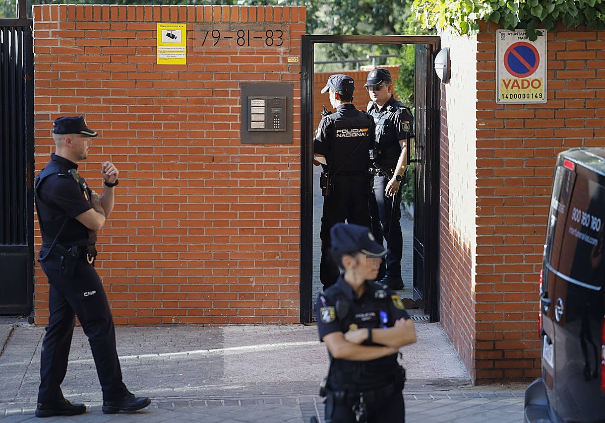 La Policía Nacional y miembros de la funeraria, en el exterior del edificio en el que ha ocurrido el crimen