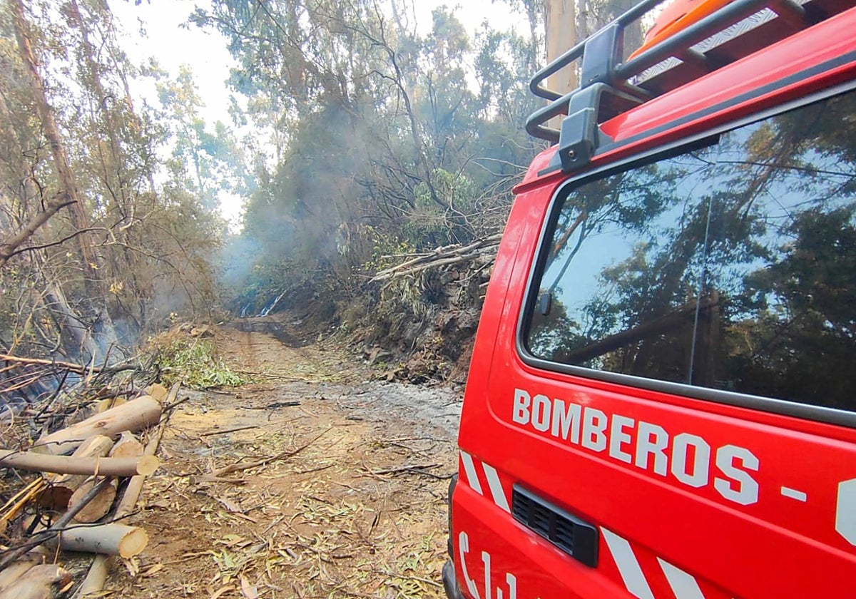 Un camión de bomberos bloquea una vía afectada por el incendio forestal