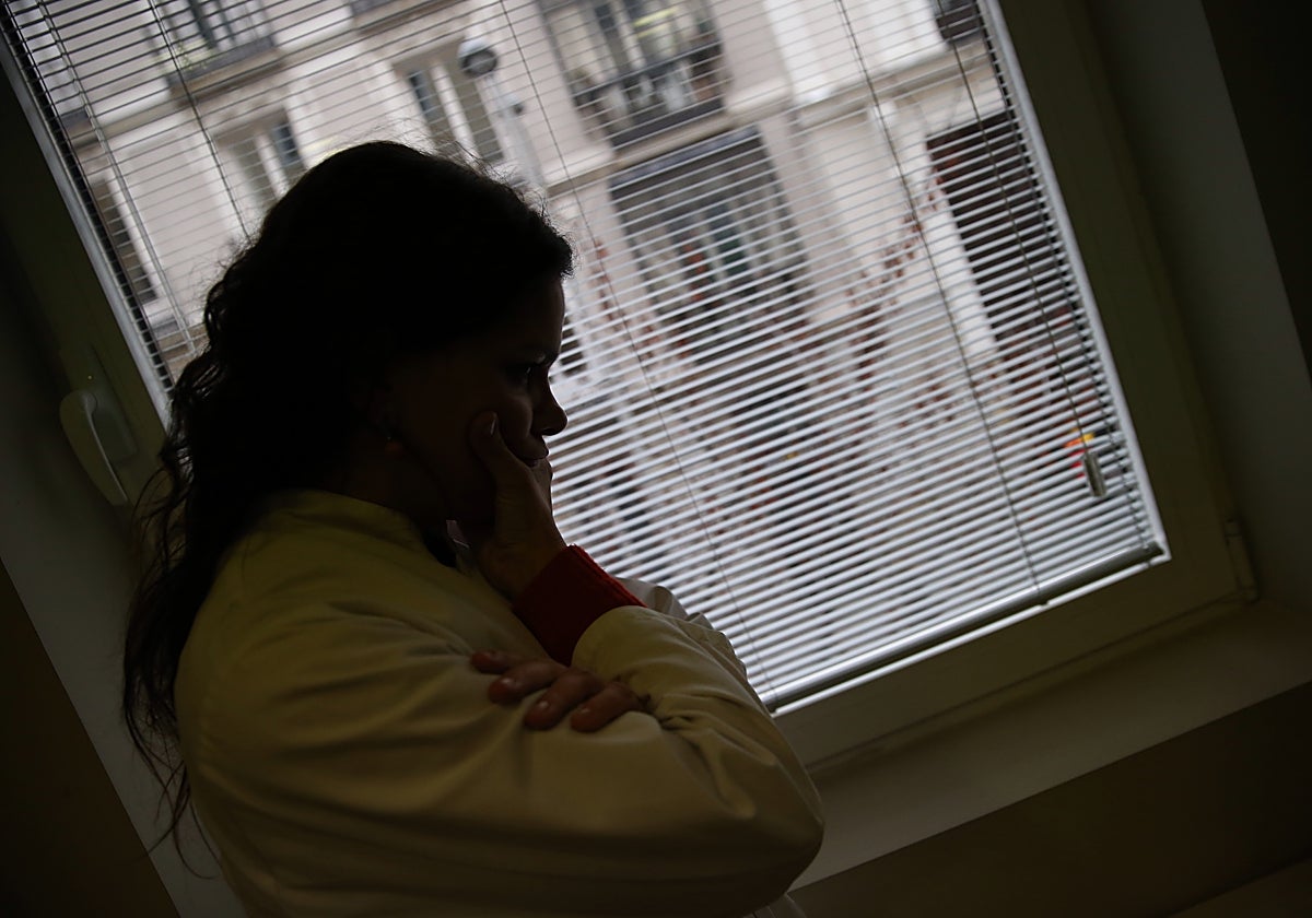 Una profesional en bata, apesadumbrada en su consulta