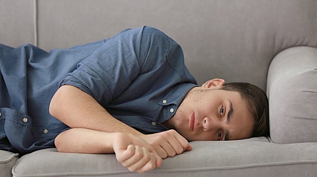Un joven entristecido en el sofá