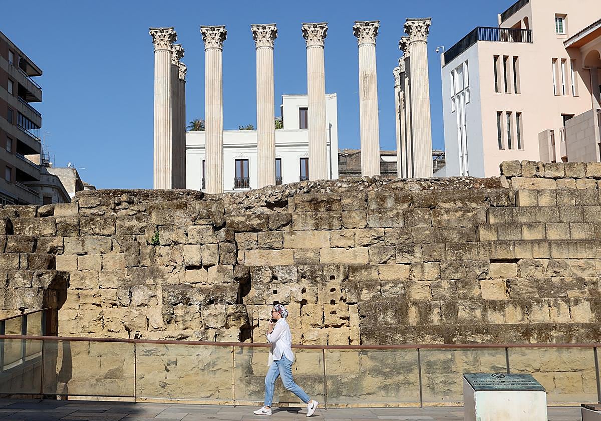 Una mujer pasa delante del Templo Romano