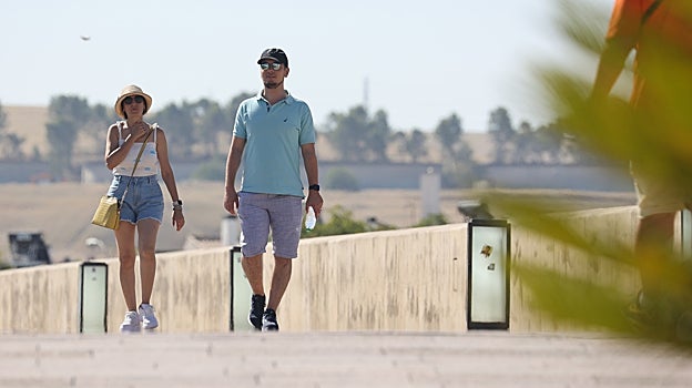 Dos personas caminan por el Puente Romano
