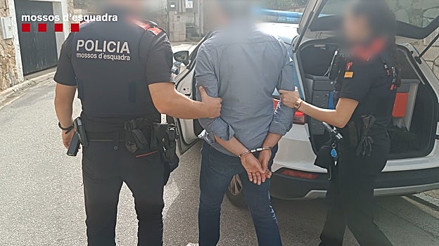 El detenido, custodiado por dos policías