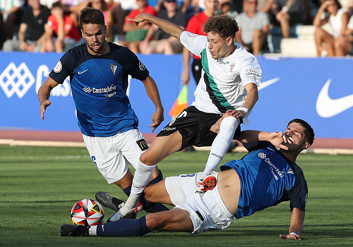 Simo intenta llevarse el balón ante dos rivales del San Fernando