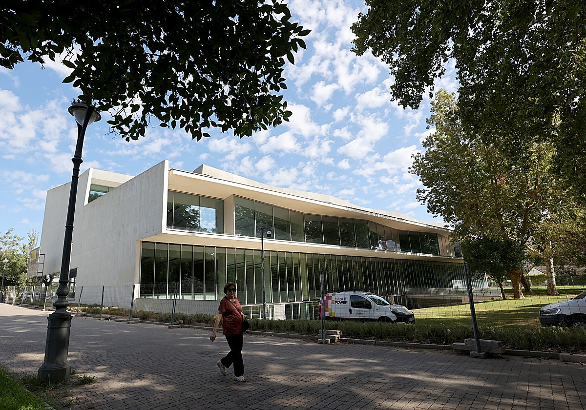 Una mujer delante de la Biblioteca de Los Patos, cercada