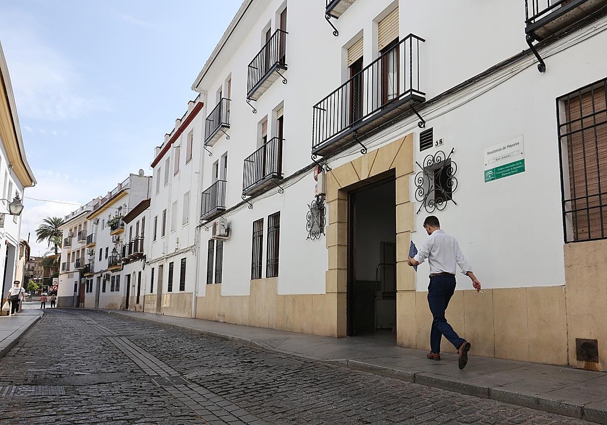 Un joven camina por la acera junto al centro geriátrico