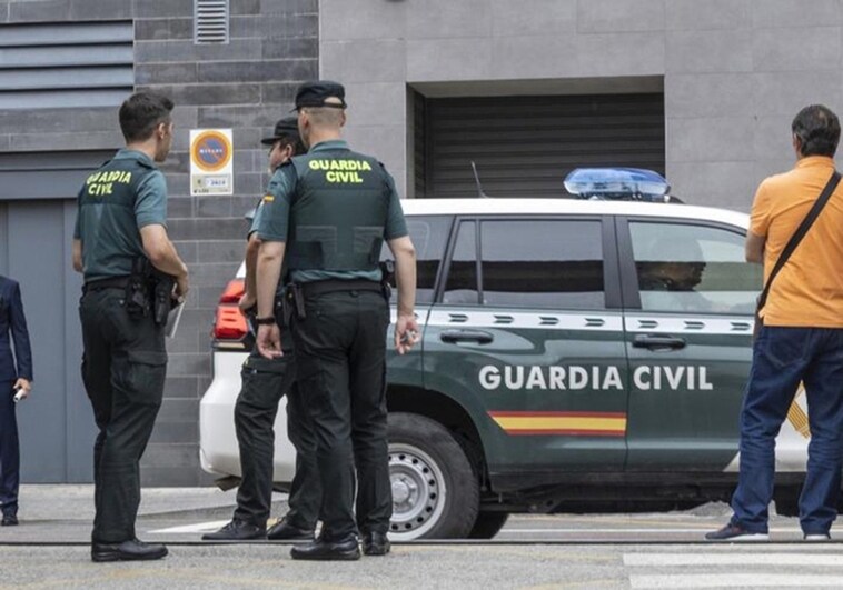 Imagen de archivo de tres agentes de la Guardia Civil junto a una patrulla