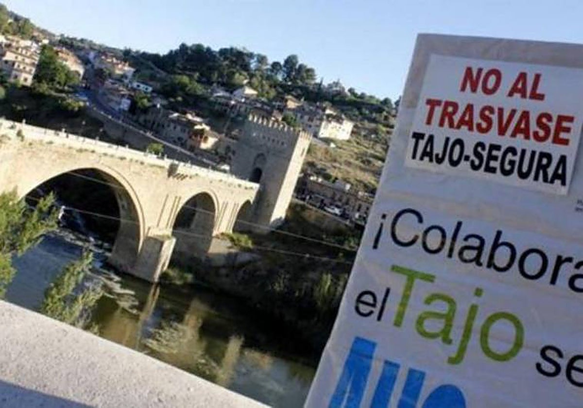 Cartel de una manifestación contra los trasvases del Tajo al Segura junto al cauce del río en Toledo