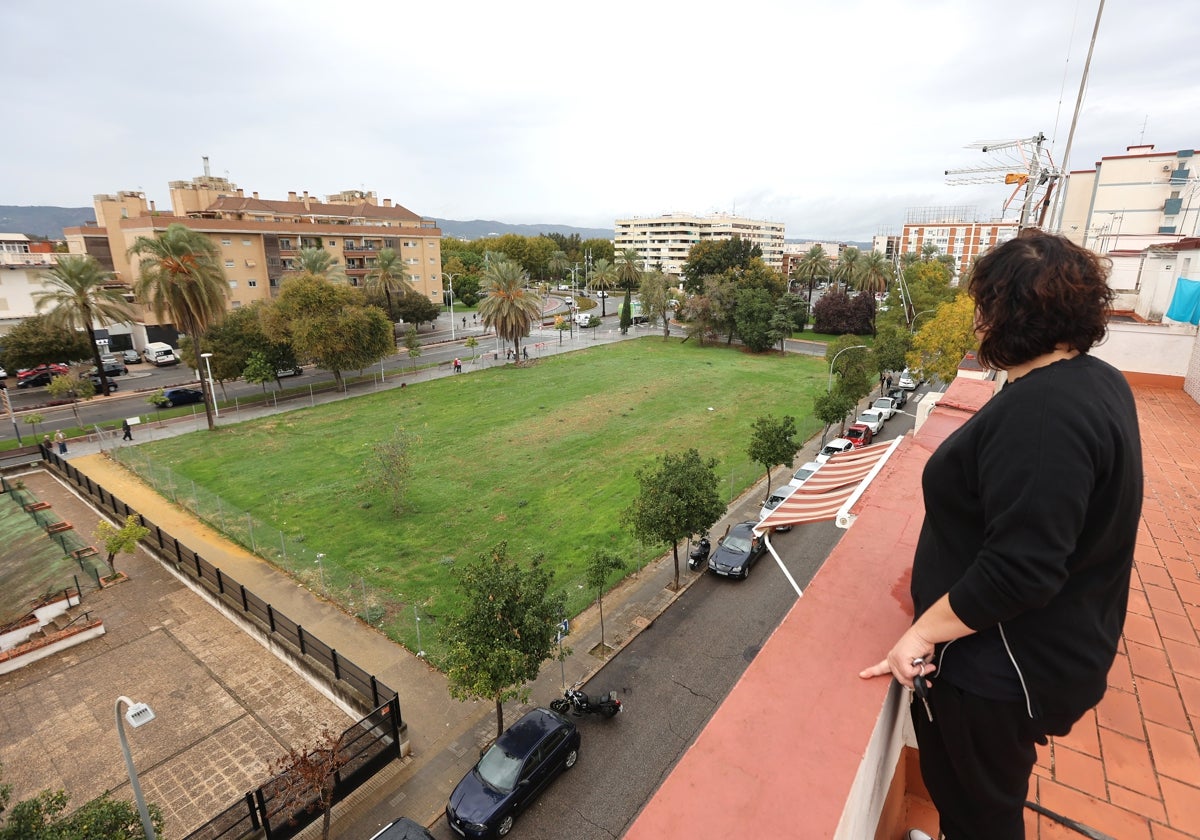 Una vecina contempla el solar vallado y vacío del antiguo pabellón de la Juventud en el Sector Sur de Córdoba