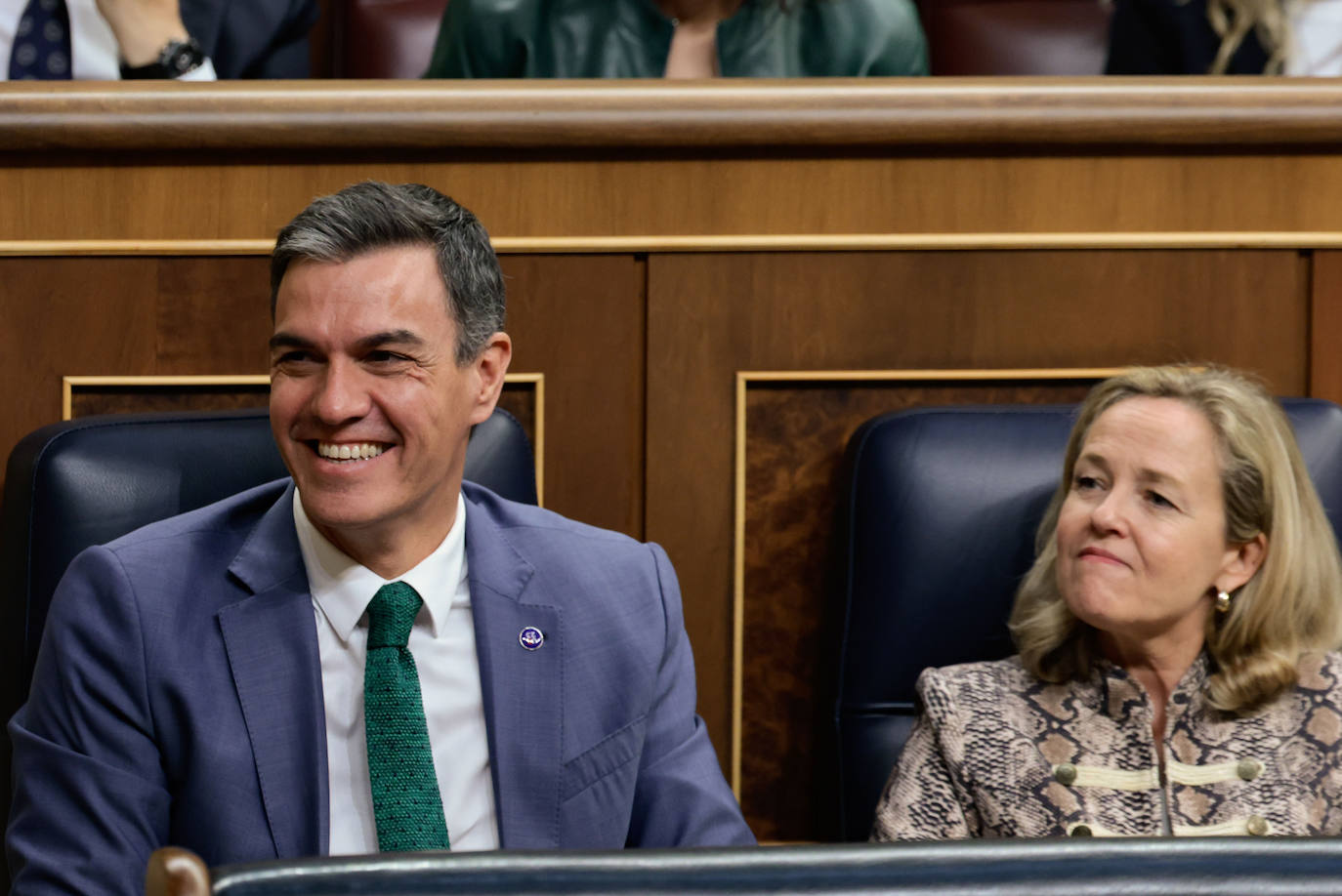 El presidente en funciones del Gobierno, Pedro Sánchez, suelta la risa durante el discurso de Alberto Núñez Feijóo sin conseguir la reciprocidad de la vicepresidenta en funciones, Nadia Calviño