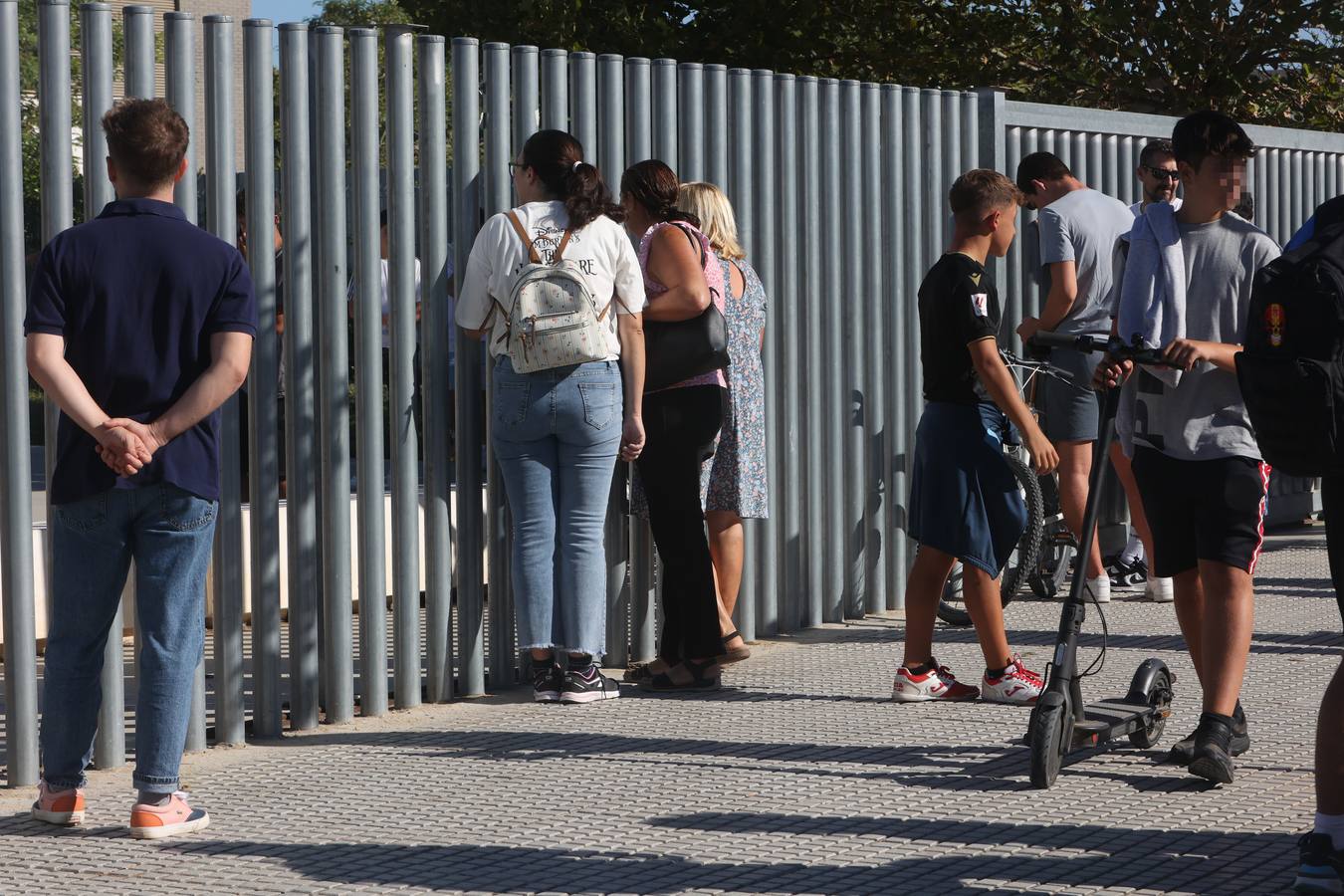 A través de la valla, algunos padres y familiares de los alumnos del Instituto de Educación Secundaria (IES) Elena García Armada de Jerez de la Frontera (Cádiz) donde un menor ha herido a tres profesores y a dos alumnos, hablan con los estudiantes