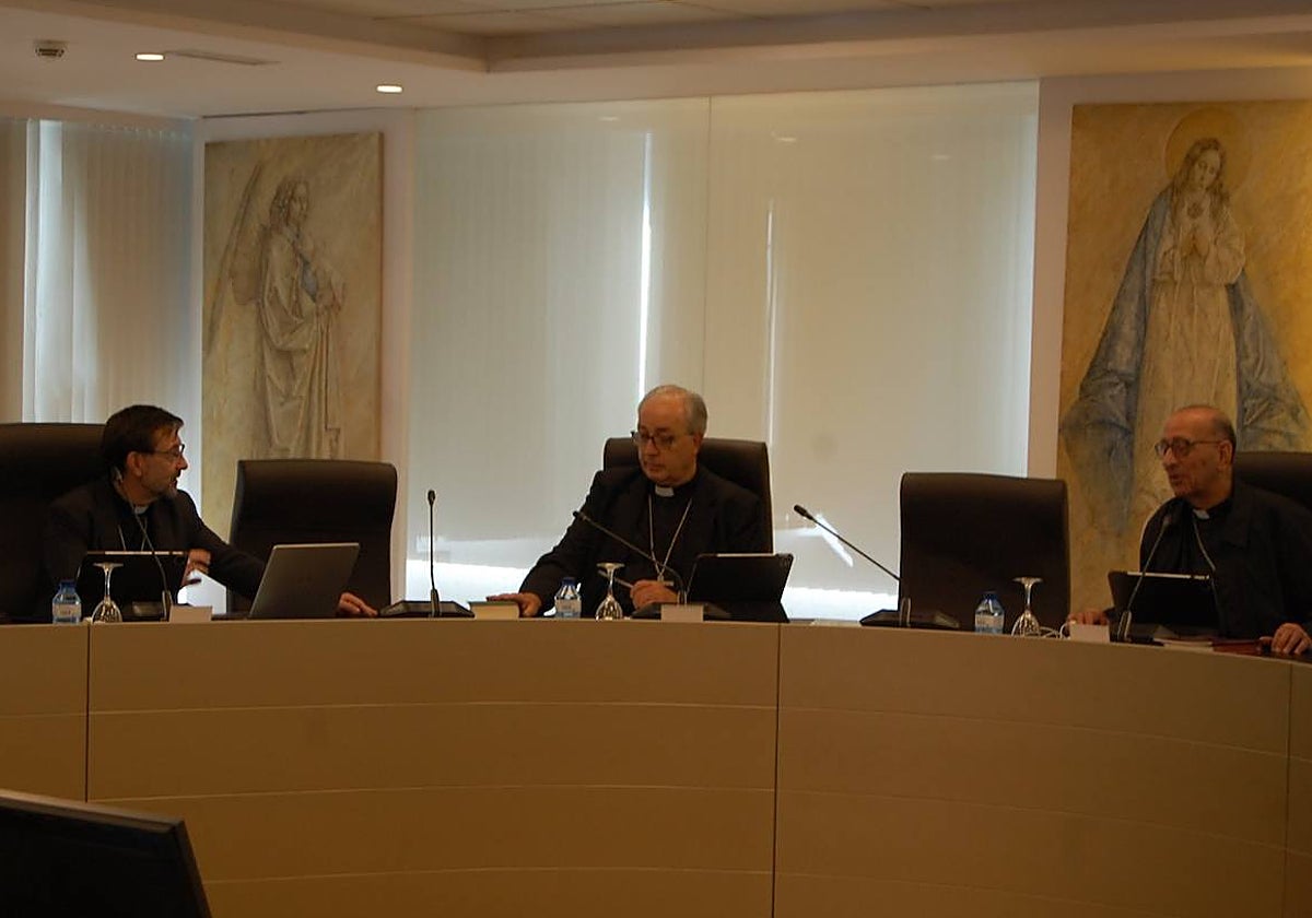 El arzobispo de Madrid, José Cobo (iz.) y el de Barcelona, Juan José Omella, dialogan en un momento de la Permanente. En el centro, el portavoz, César García Magán
