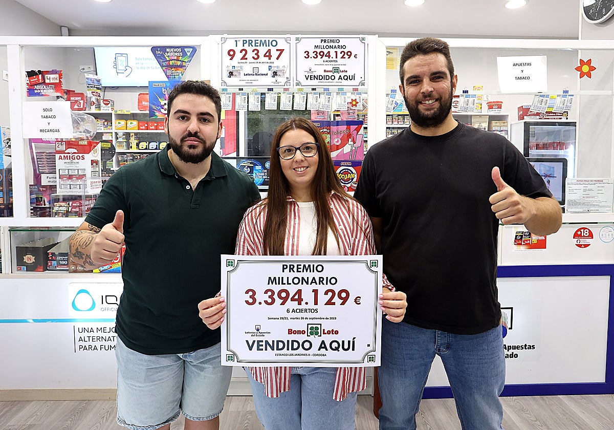 Los encargados del establecimiento del barrio del Guadalquivir con un cartel del número premiado