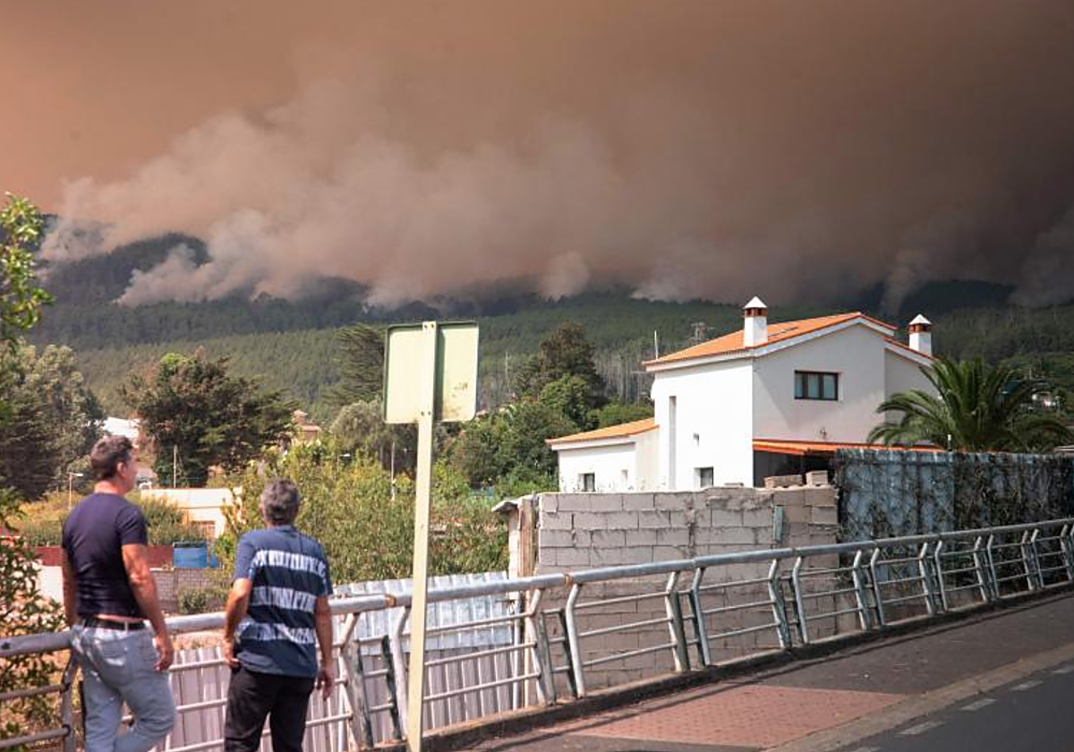 Vecinos de El Rosario observan el fuego del incendio del pasado mes de agosto, reactivado hoy