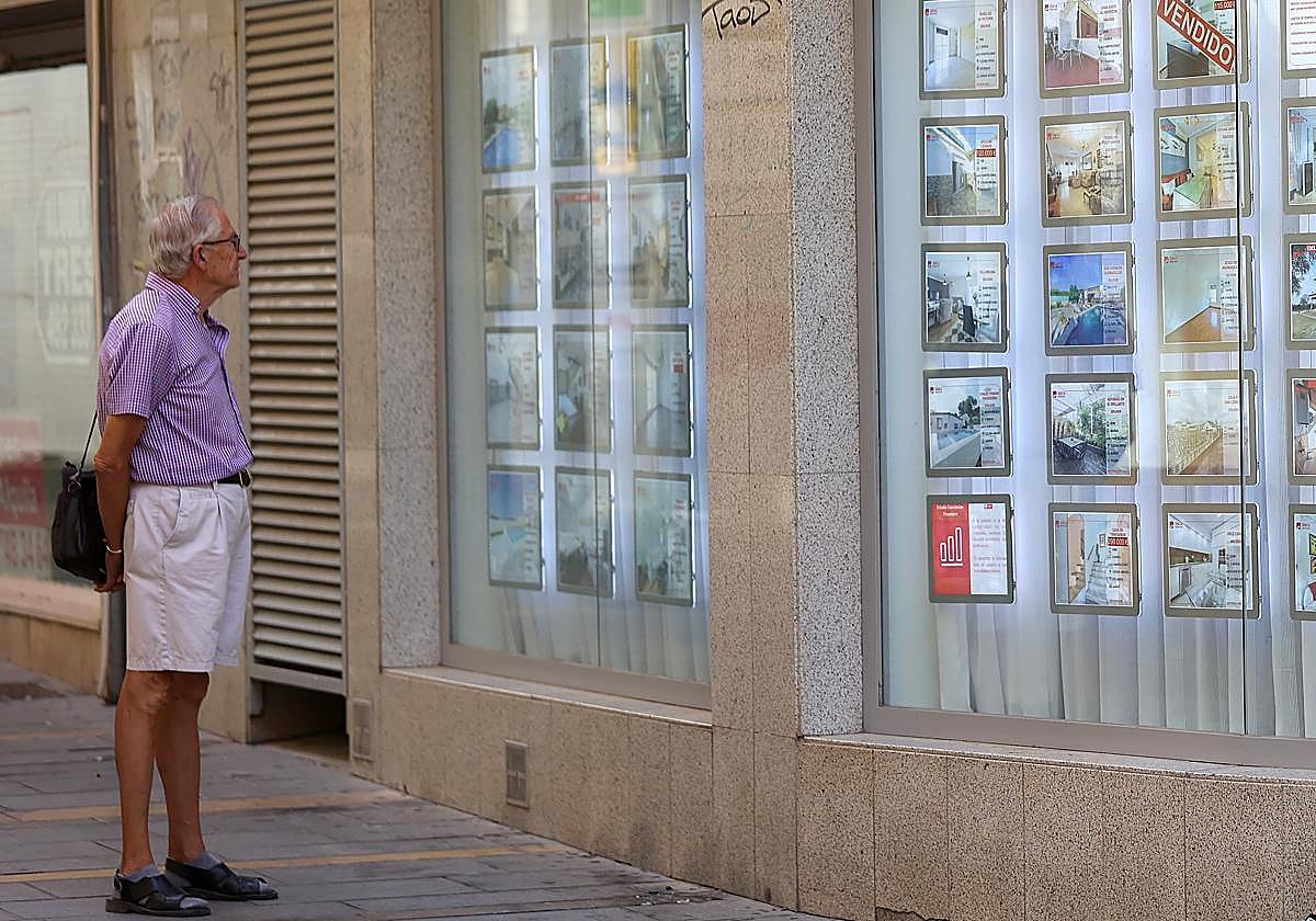 Un hombre observa los pisos en venta y alquiler en una inmobiliaria del Centro