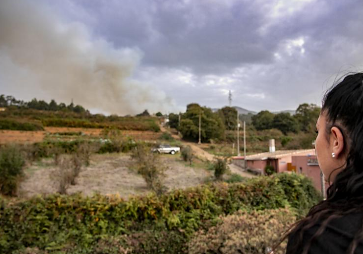 Una vecina obseerva la columna de humo de la reactivación en El Sauzal