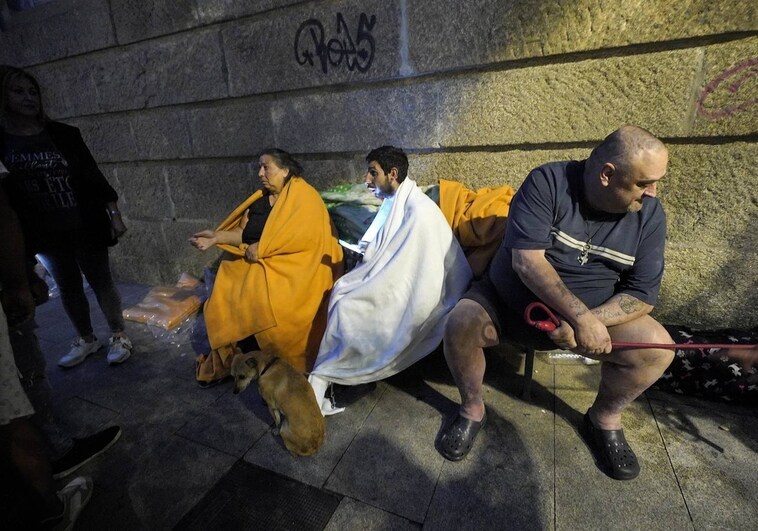 Vecinos afectados por el incendio, cubiertos con mantas en la calle