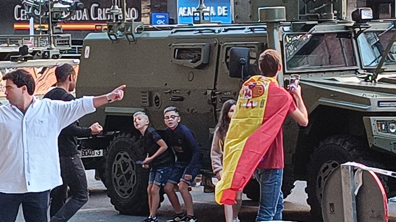 Dos niños, frente a uno de los camiones militares que se han visto este 12-O 