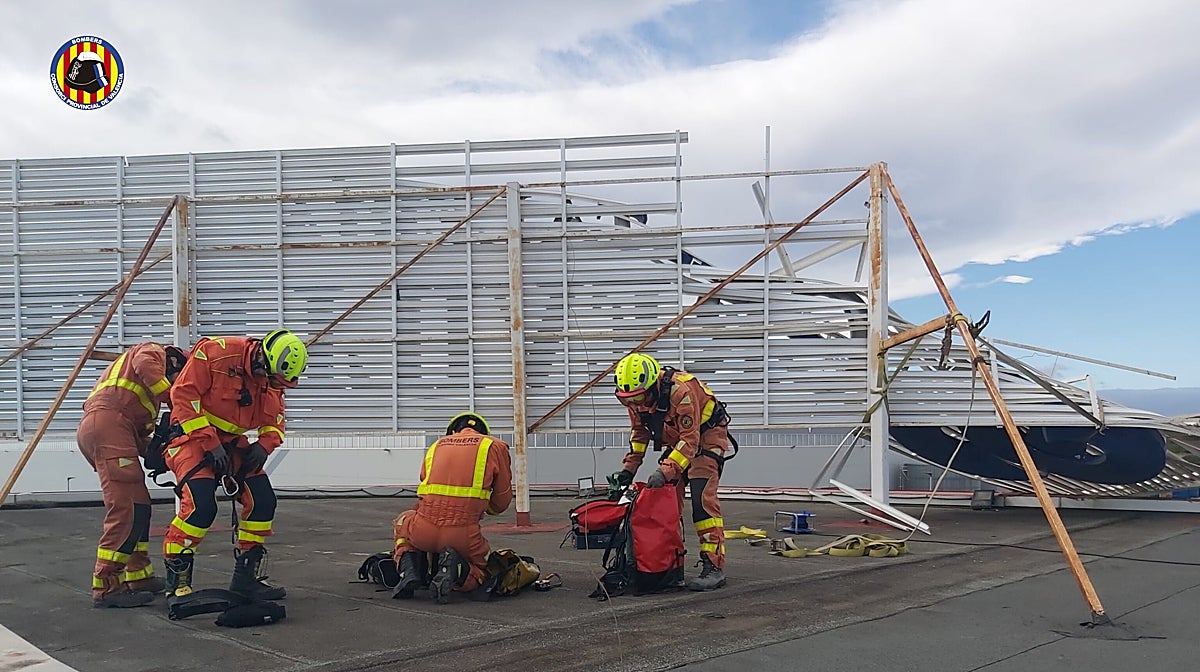 Imagen de los trabajos de bomberos para asegurar carteles publicitarios en Valencia