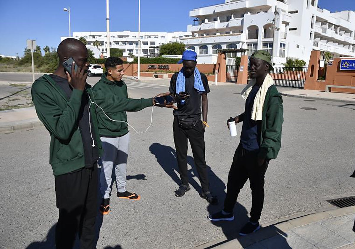 Algunos de los migrantes llegados ayer a Almería desde Canarias, junto al hotel donde están siendo atendidos