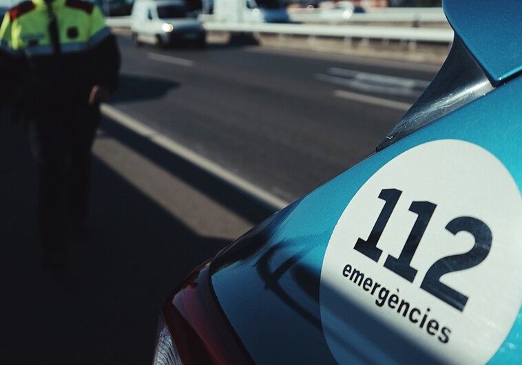 Un agente, junto a una patrulla de la Policía Catalana