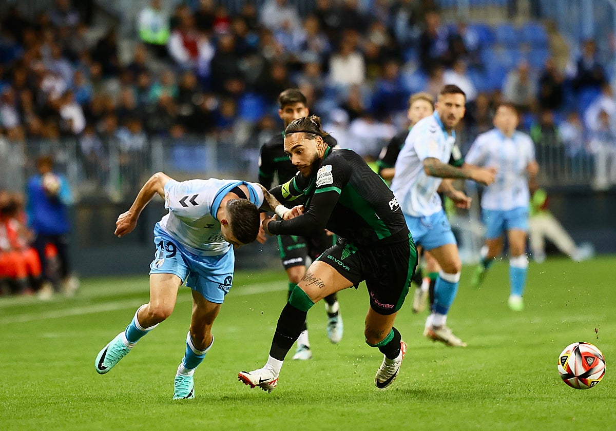 Gudelj pelea por el balón ante un jugador del Málaga