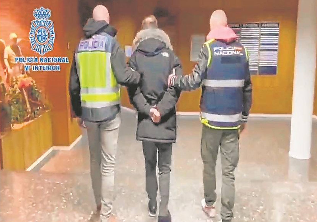 Dos agentes trasladan al sospechoso, ya detenido, a dependencias policiales