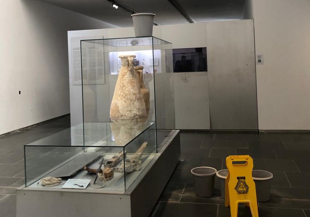 Varios cubos para las goteras junto a ánforas y otras piezas expuestas en el museo