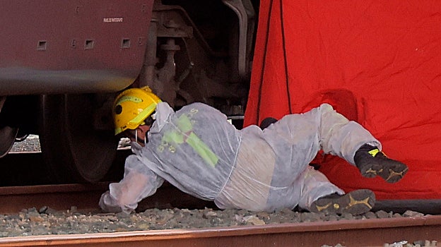 Un policía toma muestras del vagópn en que apareció Álvaro Prieto