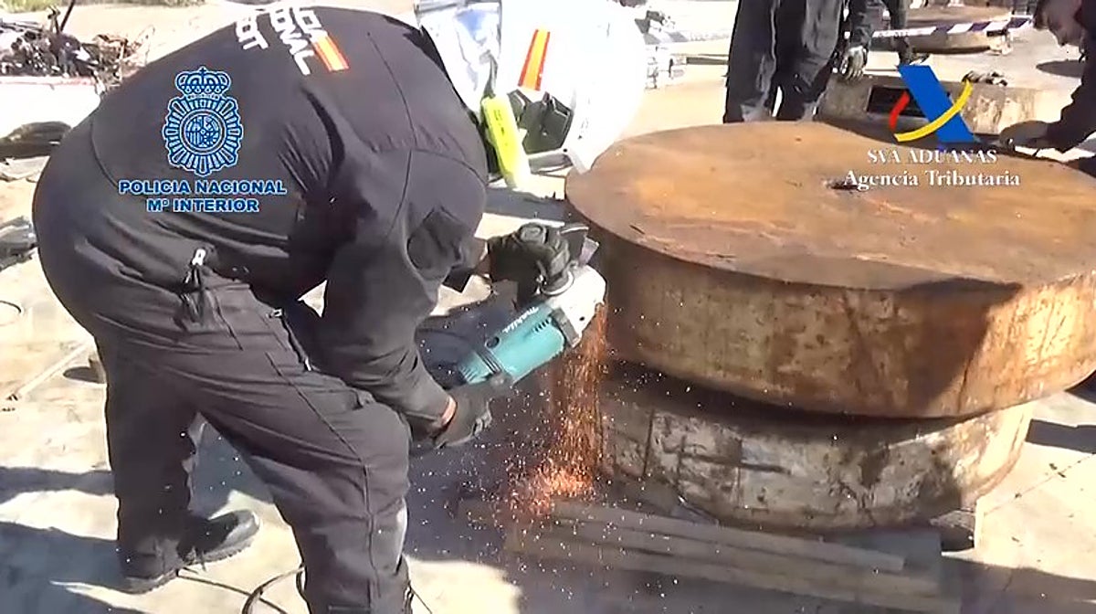 Un policía corta uno de los cilindros donde se ocultaba la cocaína oculta.